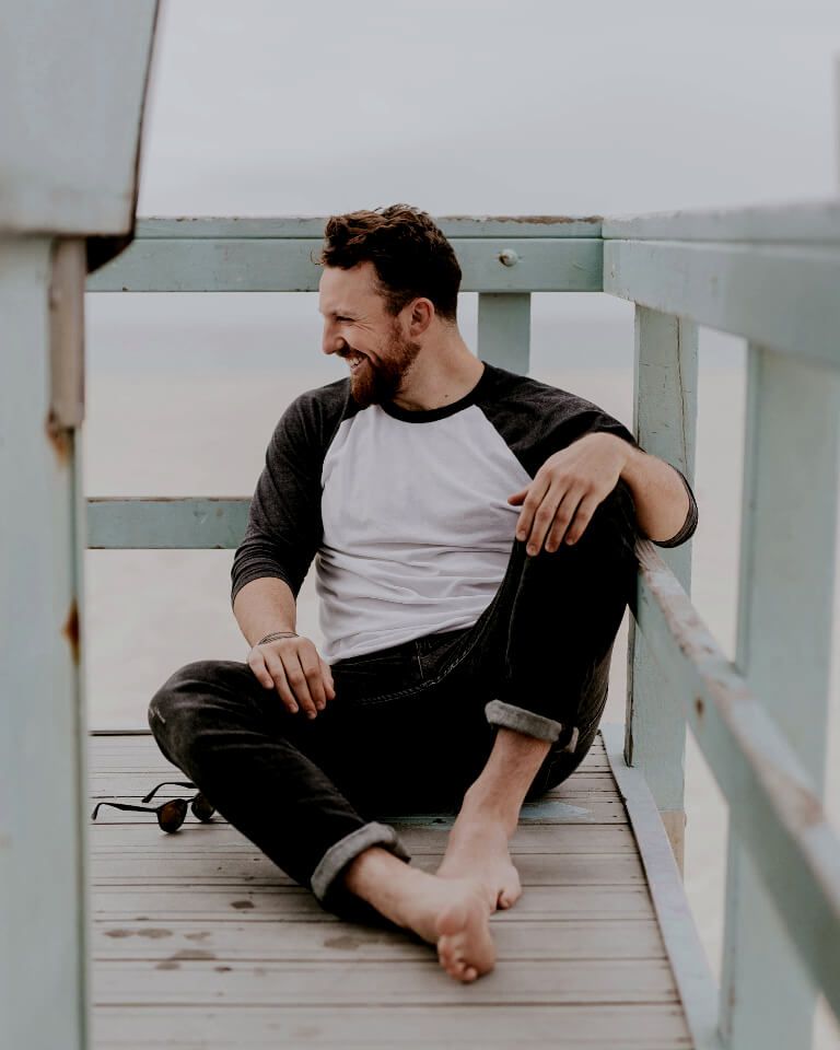  Man sitting on a structure relaxing and smiling